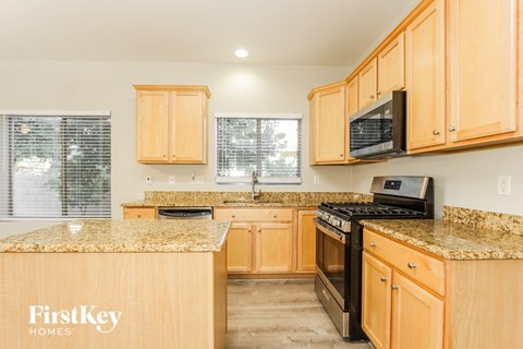 A kitchen with wooden cabinets and granite countertops.