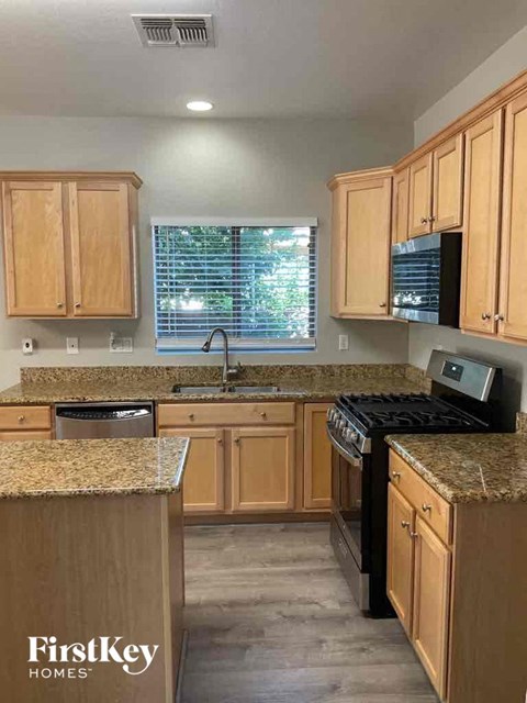 A kitchen with wooden cabinets and granite countertops.