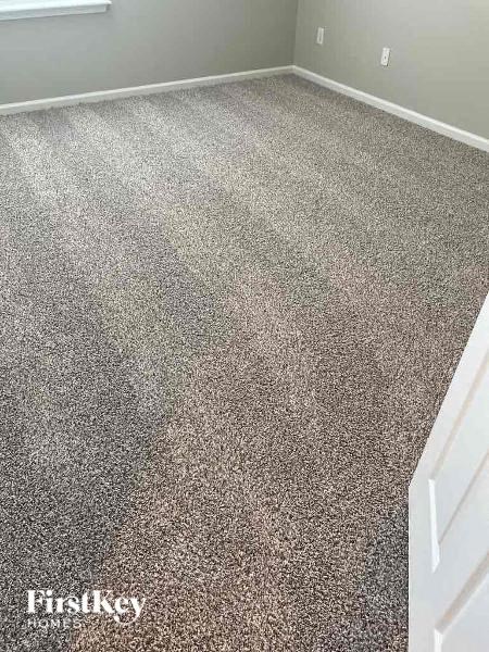 a carpeted room with a gray floor and a white door