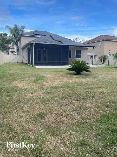a backyard with a house and a grass yard