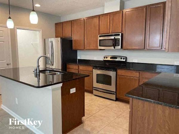 a kitchen with wooden cabinets and a black counter top