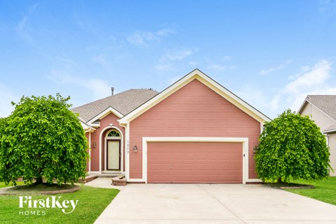 A house with a red garage door is for sale by FirstKey Homes.