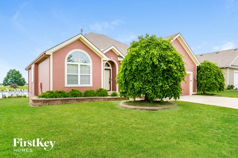A red house with a tree in front of it.