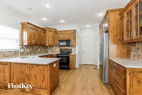 A kitchen with wooden cabinets and a refrigerator.