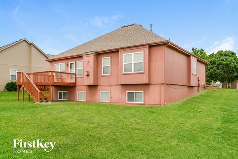 A house with a brown roof and a pink exterior is shown.