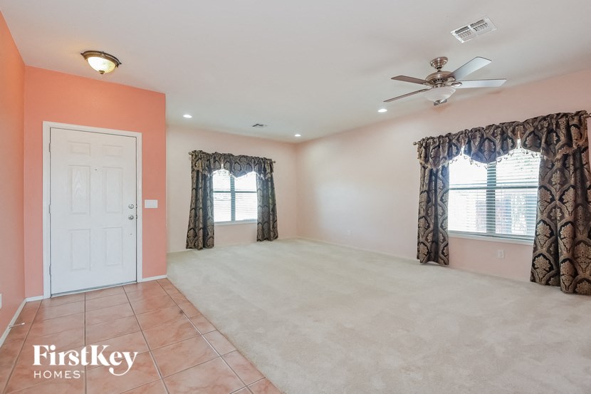 A room with a ceiling fan and a door.