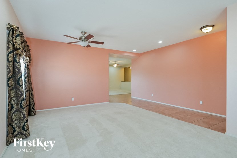 A room with a ceiling fan and a doorway leading to another room.