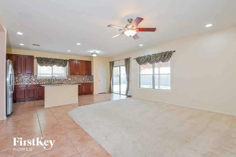 A spacious room with a fan and a rug on the floor.