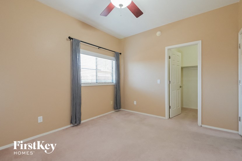 A room with a window and a fan.