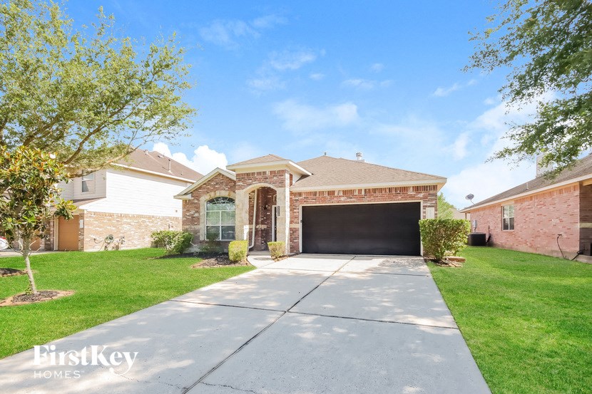 a brick house with a driveway and a garage door