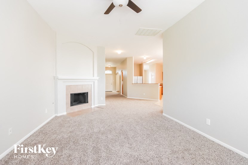 a living room with a fireplace and a carpeted floor