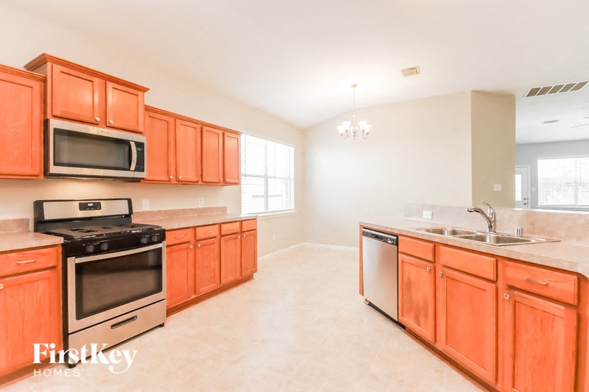 a kitchen with wooden cabinets and stainless steel appliances