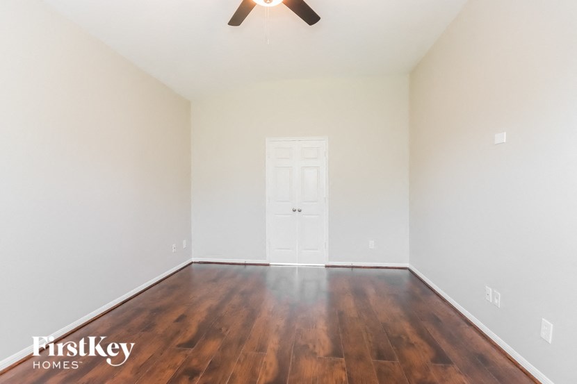 the living room with hardwood flooring and a ceiling fan