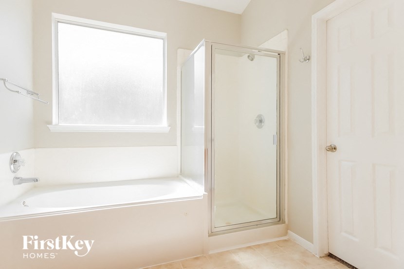 a bathroom with a tub and a shower and a window