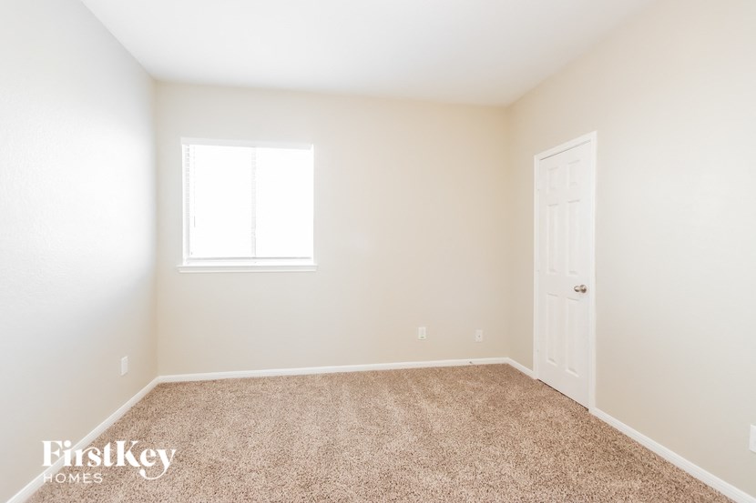 a room with carpet and a door and a window