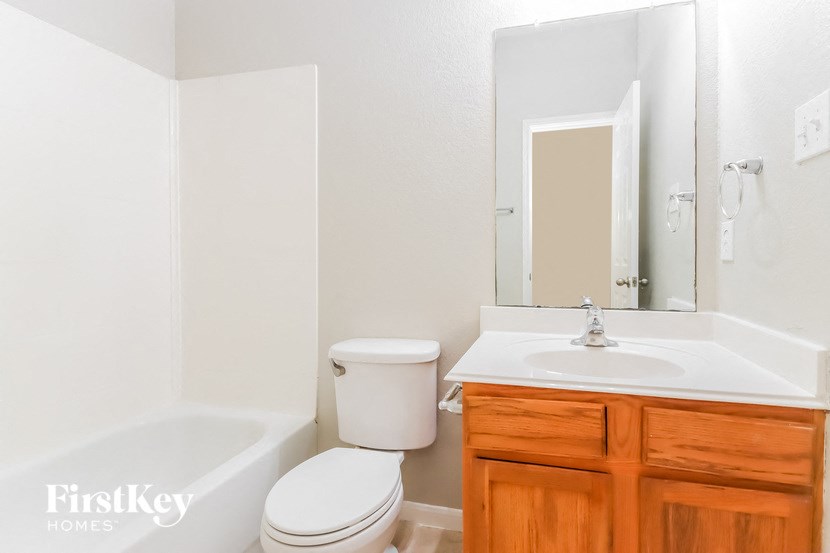 a bathroom with a sink toilet and a mirror