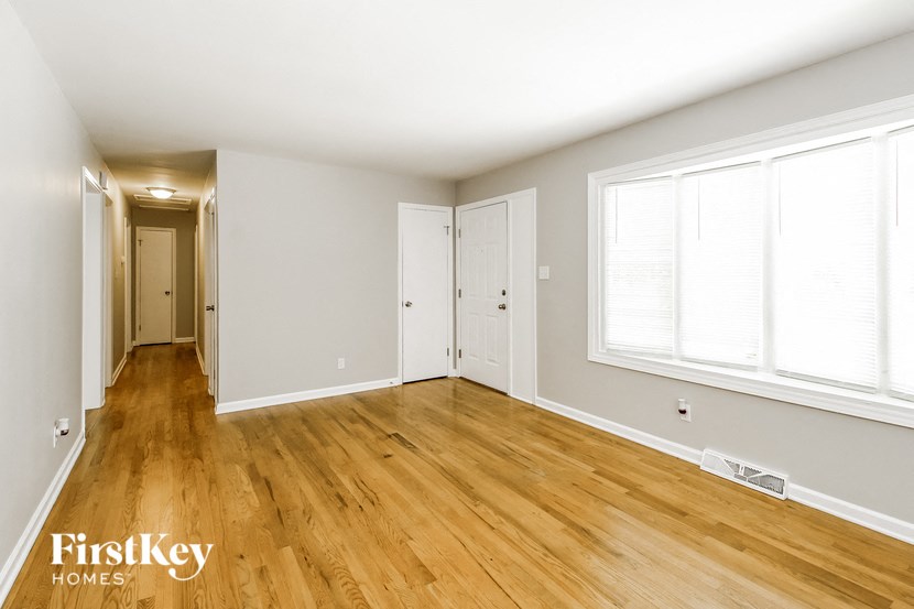 an empty living room with wood floors and white walls