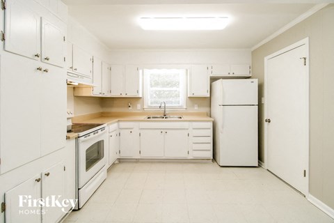 a white kitchen with white appliances and white cabinets