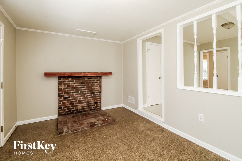 a living room with a brick fireplace and a mirror