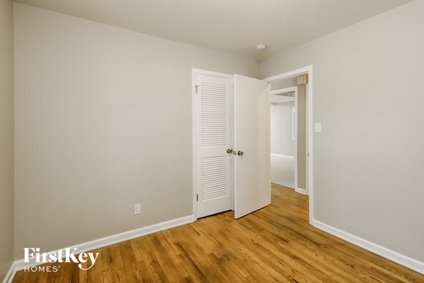 a bedroom with an open door and a door to a closet