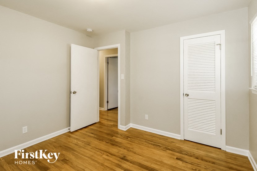 a bedroom with a closet and a door to a hallway