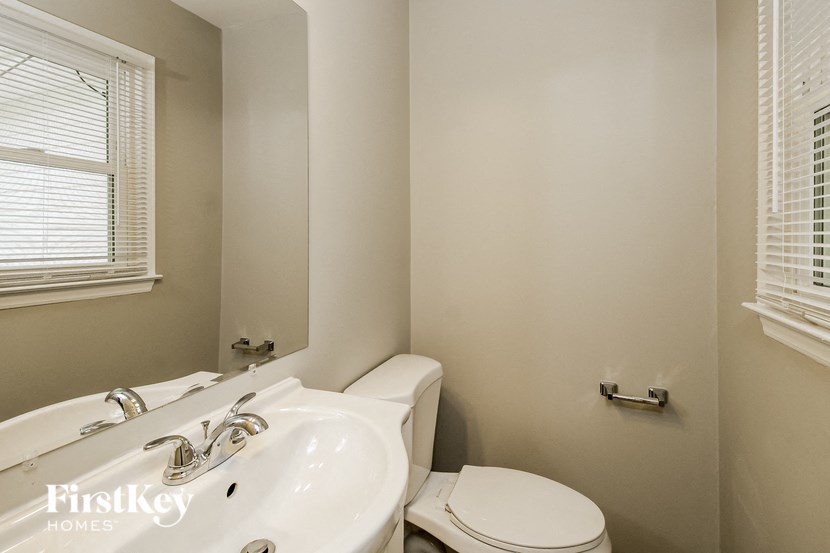 a bathroom with a toilet and a sink and a mirror