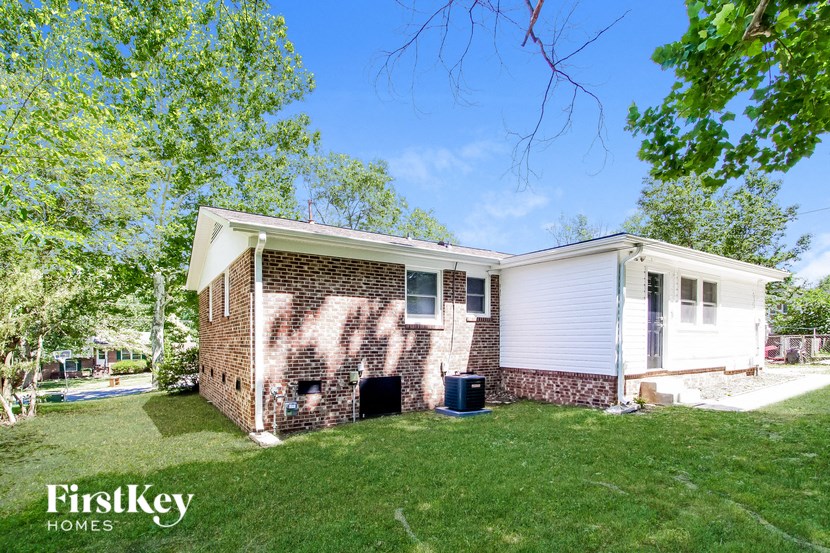 a small brick house with a yard and a tree