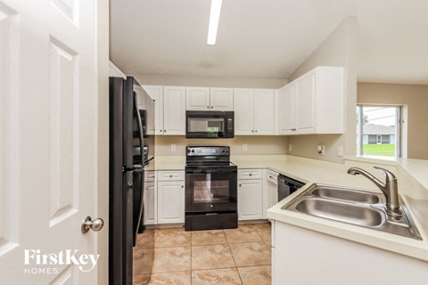a kitchen with black appliances and white cabinets