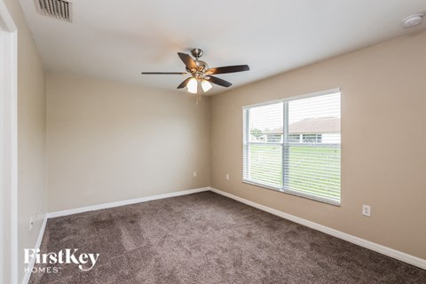 a bedroom with a ceiling fan and a window