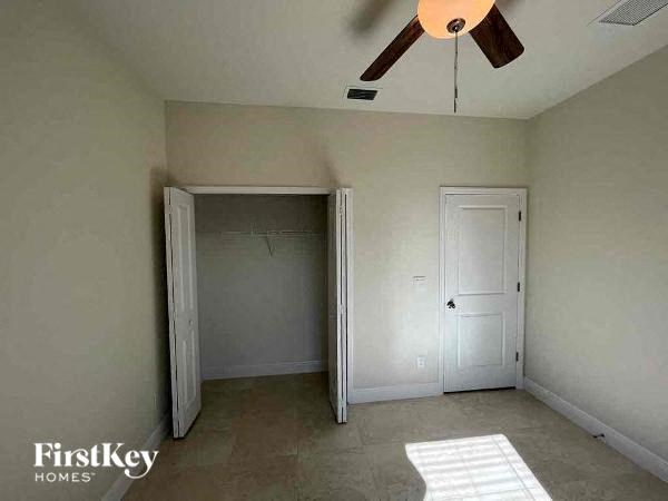 an empty room with a ceiling fan and a door