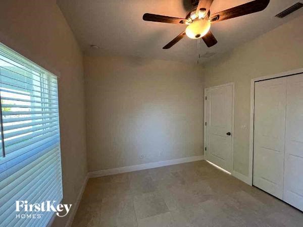 a empty room with a ceiling fan and a door