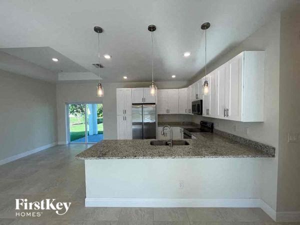 a kitchen with white cabinets and a granite counter top