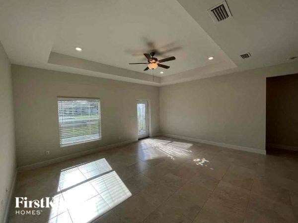 an empty living room with a ceiling fan