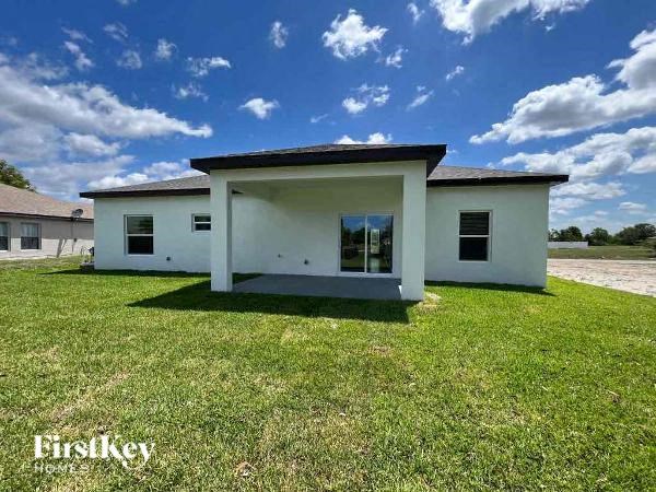 a small white house sitting in a grass field