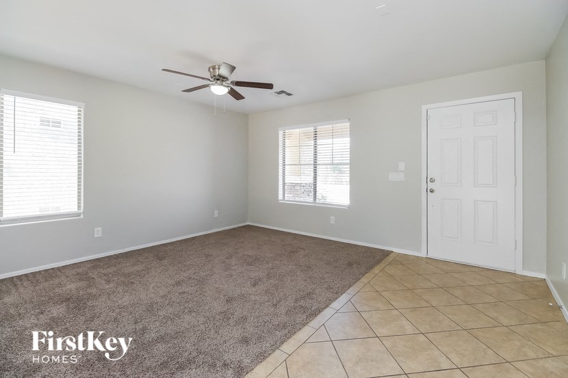 A spacious room with a fan and a carpeted floor.