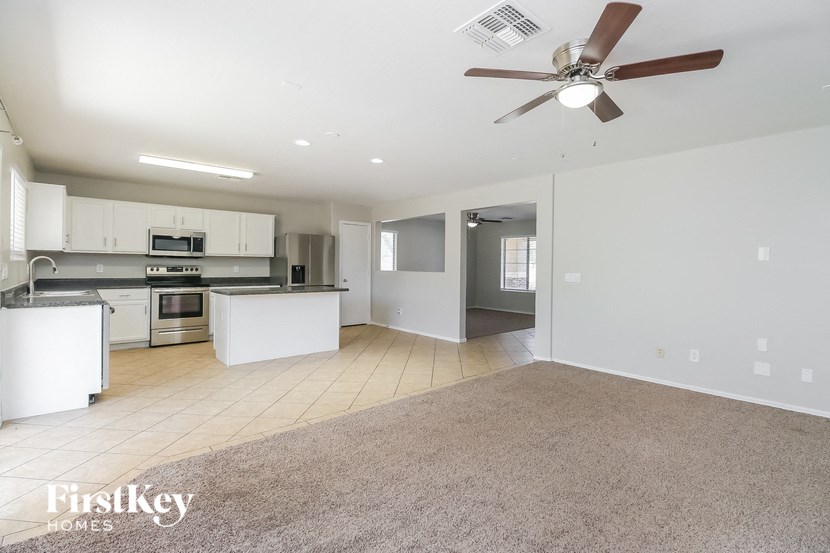 A spacious kitchen with a fan on the ceiling.