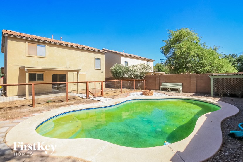 A small house with a pool in the backyard.