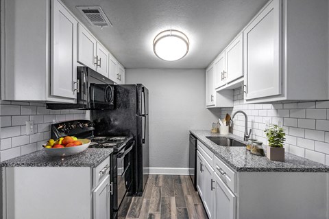 a kitchen with white cabinets and a sink and a refrigerator