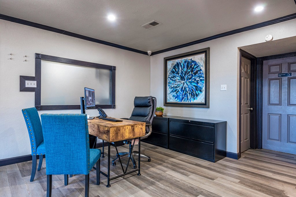 a home office with a desk and chairs and a large mirror