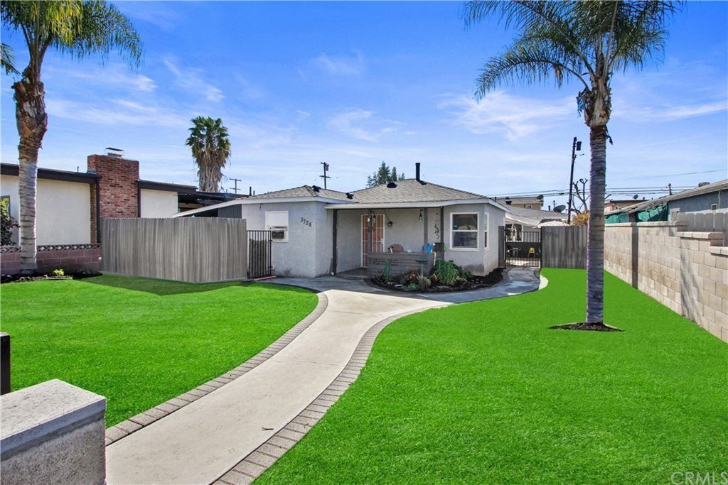 a house with a yard and palm trees