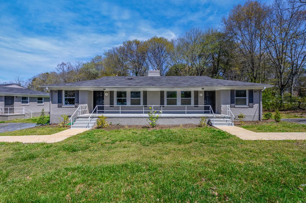 the front of a house with a porch and a lawn