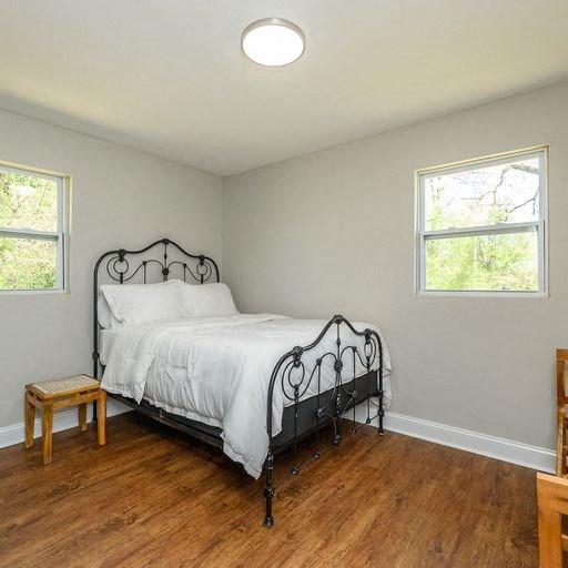 a bedroom with a bed and a wooden floor