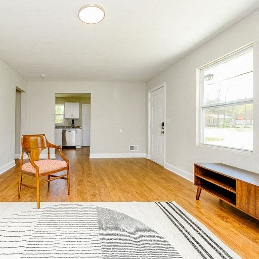 an empty living room with a chair and a rug