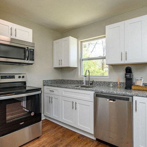 a kitchen with stainless steel appliances and white cabinets
