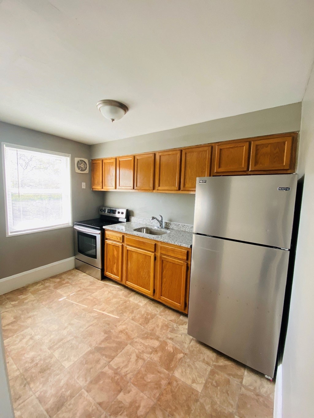a kitchen with stainless steel appliances and wooden cabinets