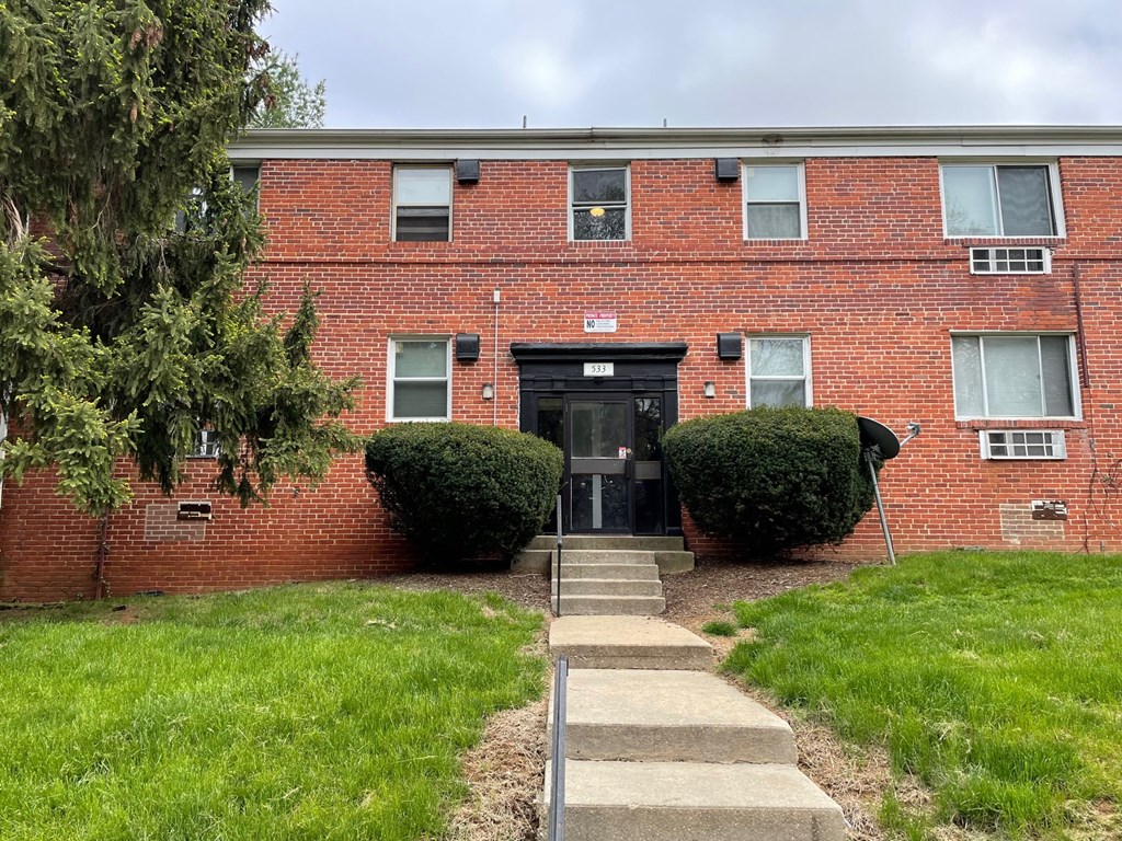 a brick building with a sidewalk in front of it