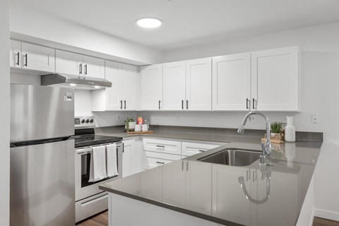 a large kitchen with white cabinets and stainless steel appliances