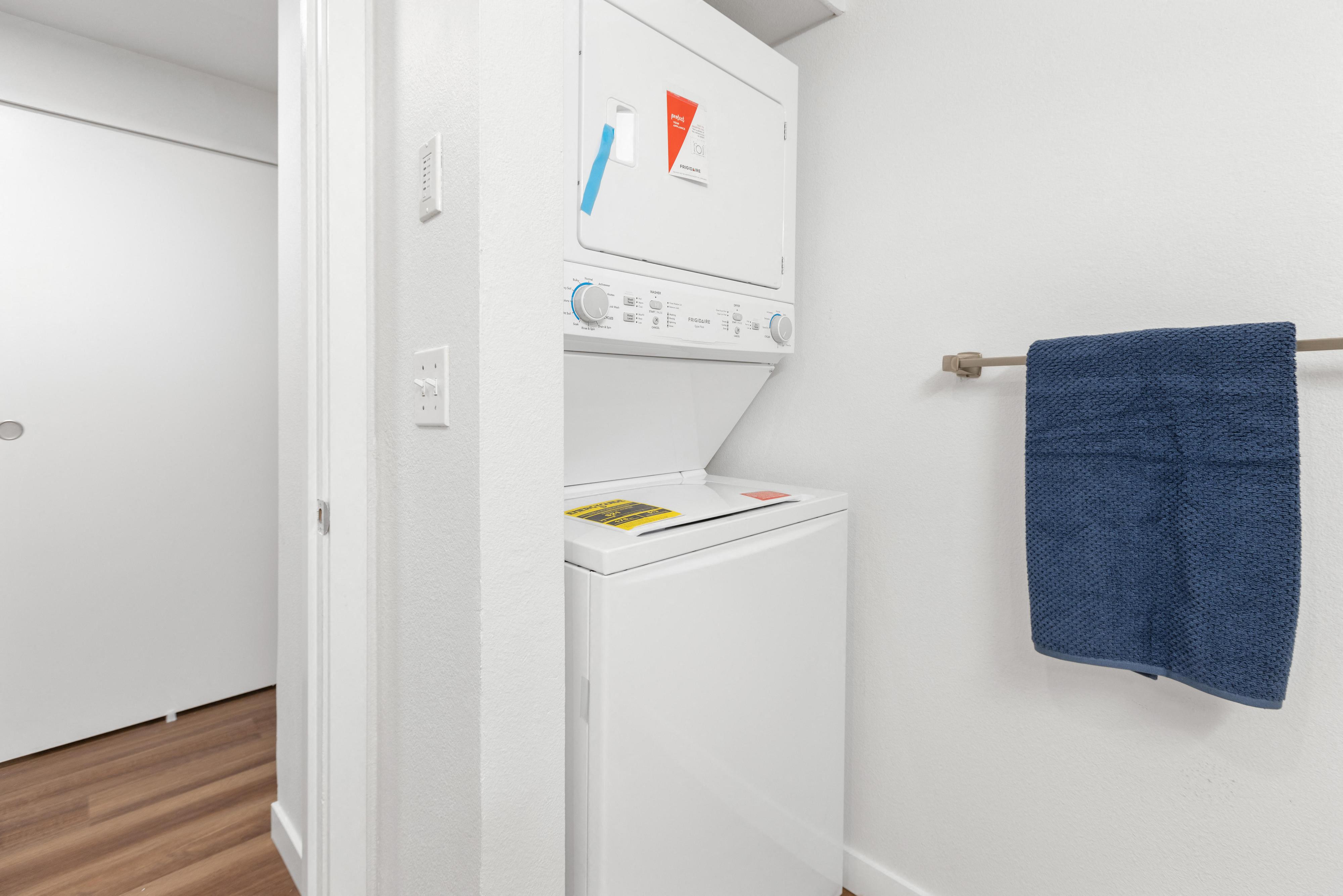 a washer and dryer in a small room in a room with a towel