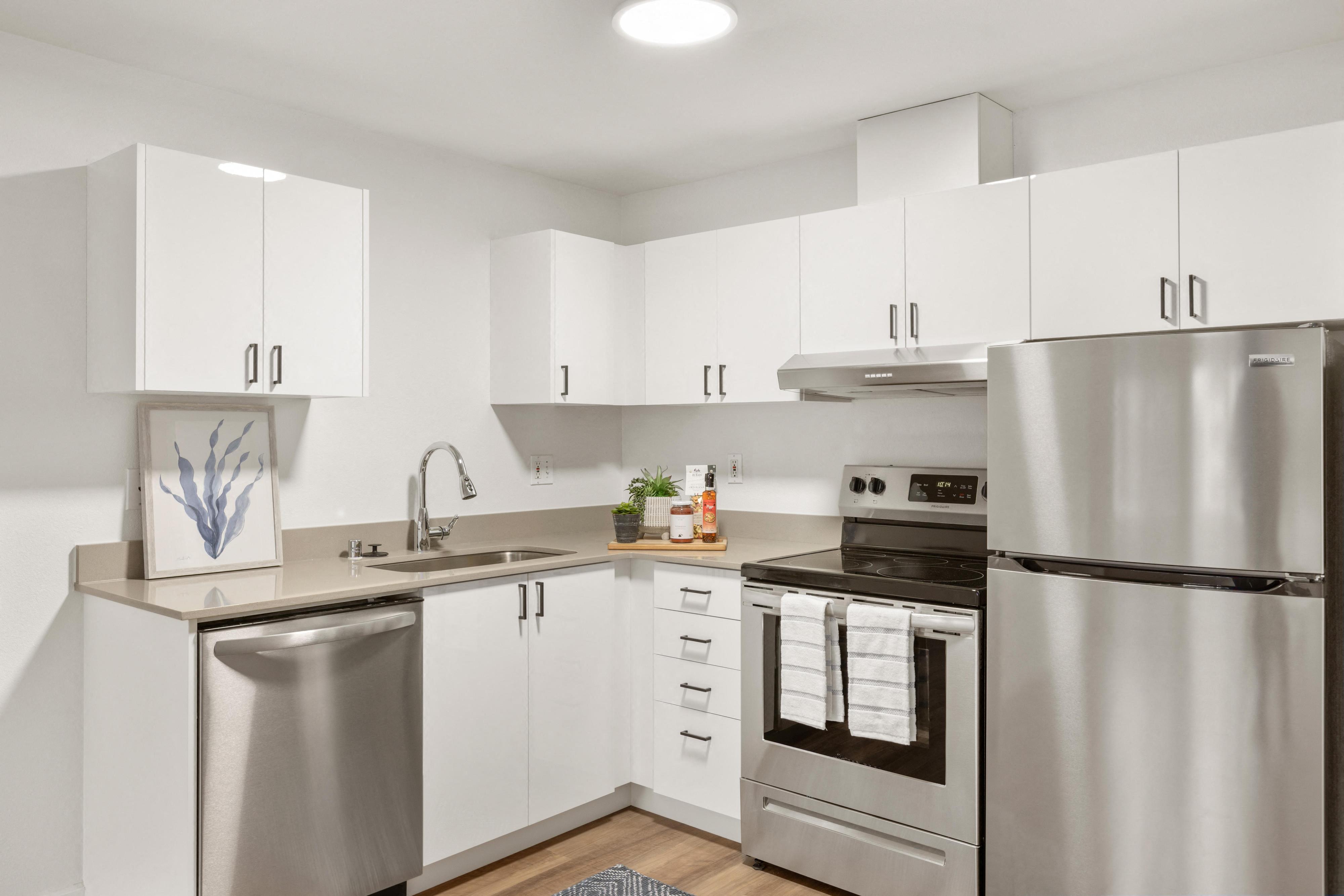 a kitchen with stainless steel appliances and white cabinets