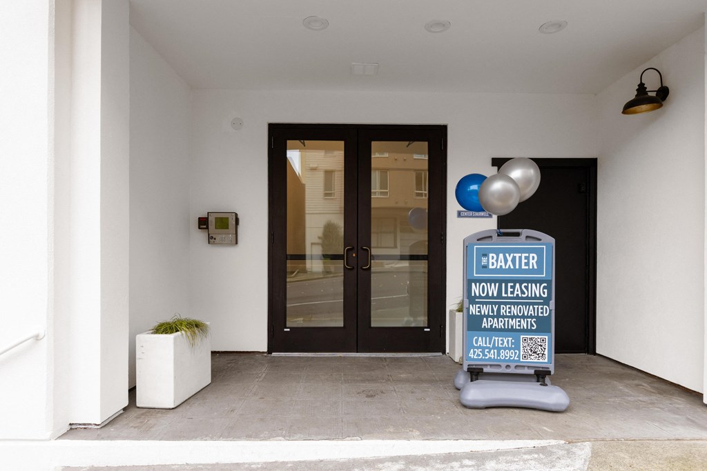 a front door of a building with a sign that says barber now easing new